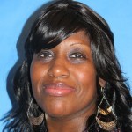 A woman with long black hair and dangling earrings.